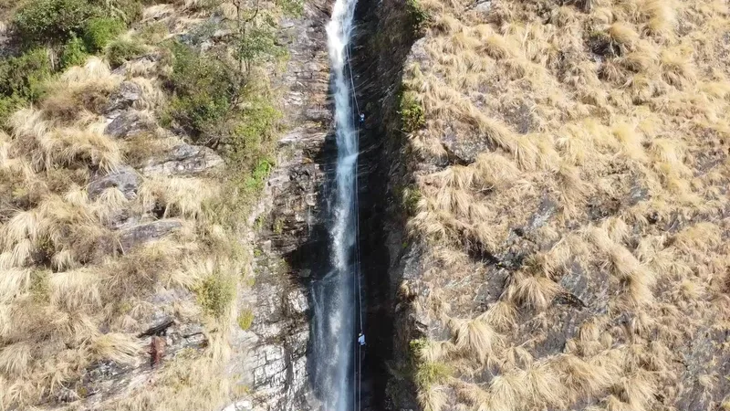 Aerial view of climbers rappelling down the Birthi waterfall